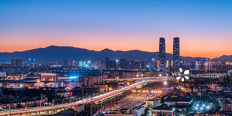 中国云南昆明双子塔、高架桥和火车站夜景图片素材