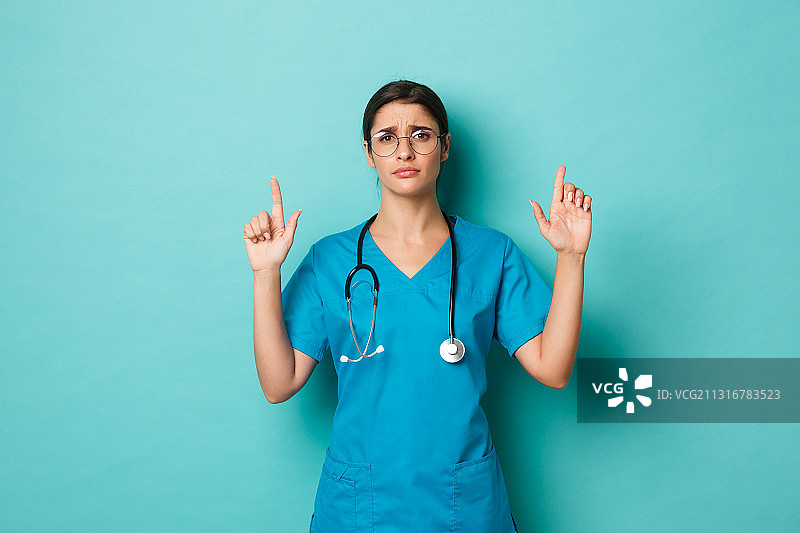 女医生在蓝色背景下竖起大拇指图片素材
