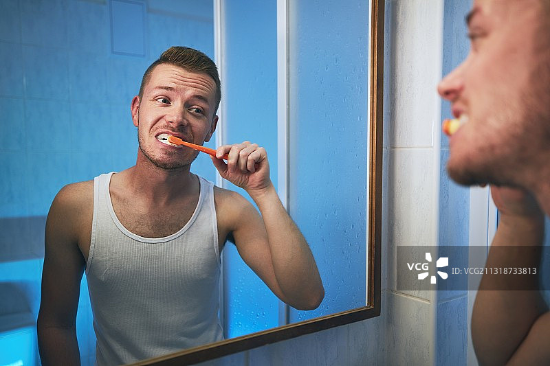 年轻人在镜子前刷牙图片素材