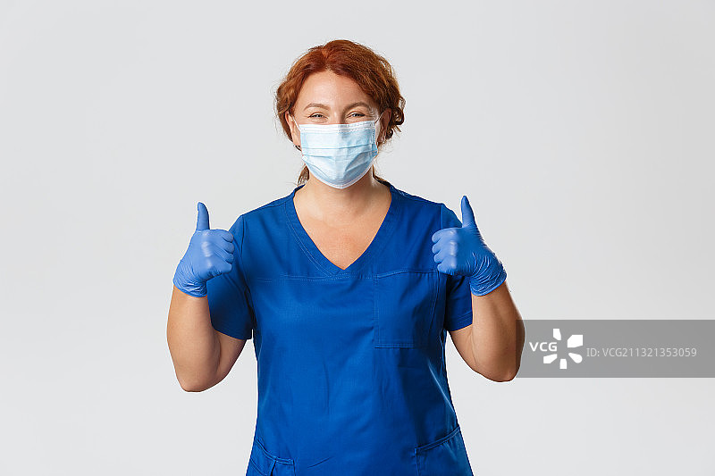 在白色背景下戴着外科口罩的女医生打手势的肖像图片素材