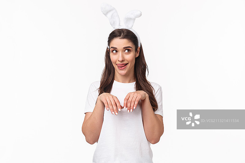 微笑女人的肖像戴着兔耳头巾，而站在白色的背景图片素材