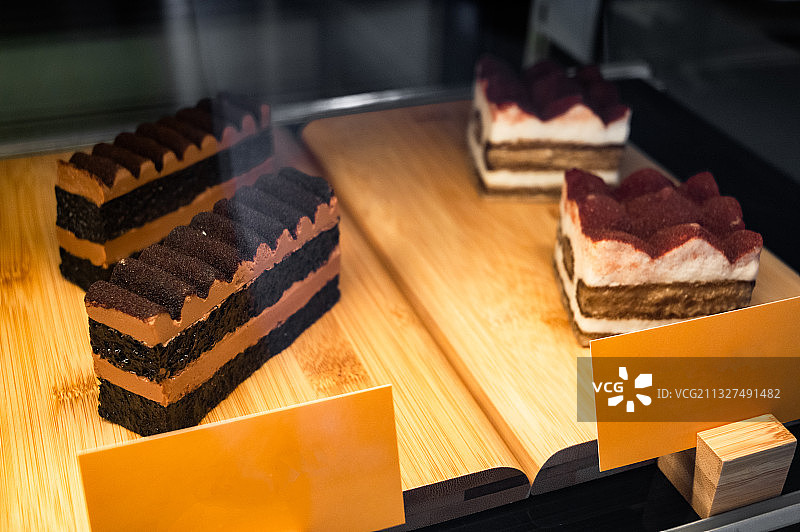 咖啡厅橱柜里的甜品小蛋糕，马卡龙，慕斯，芝士蛋糕，冰柜，冰箱图片素材