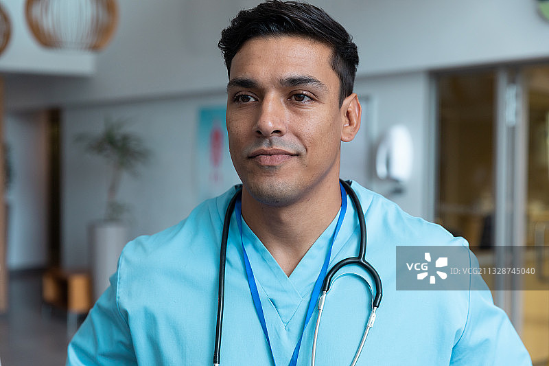 混合种族男医生的肖像与听诊器穿着手术服在医院图片素材
