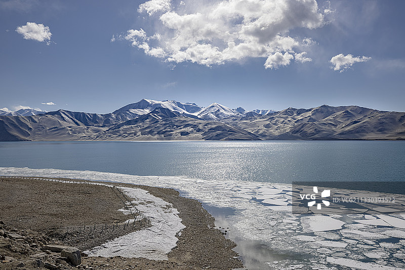 新疆高原雪山前的湖泊及岸边的浮冰图片素材