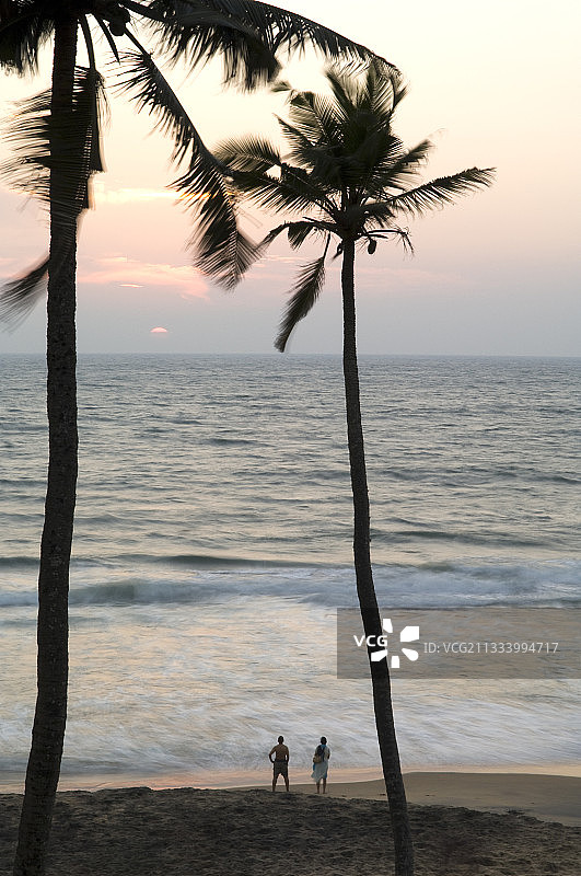印度喀拉拉邦金色日落海滩上的游客图片素材