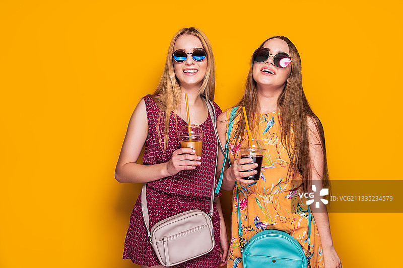 两个快乐的年轻女人女孩朋友在夏天的衣服和包图片素材