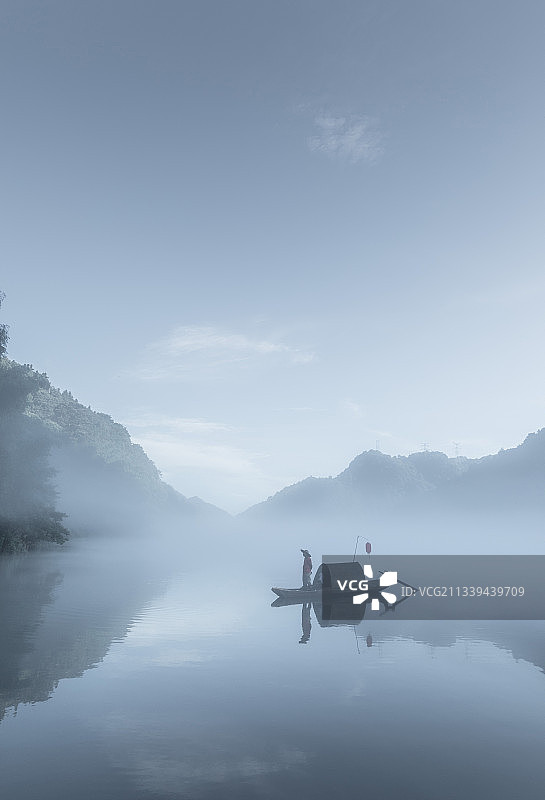 小东江的晨雾与渔夫，水墨中国风的景观。湖南郴州东江湖图片素材