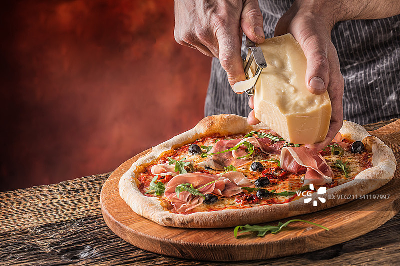 在菜板上切披萨的男人的中段图片素材