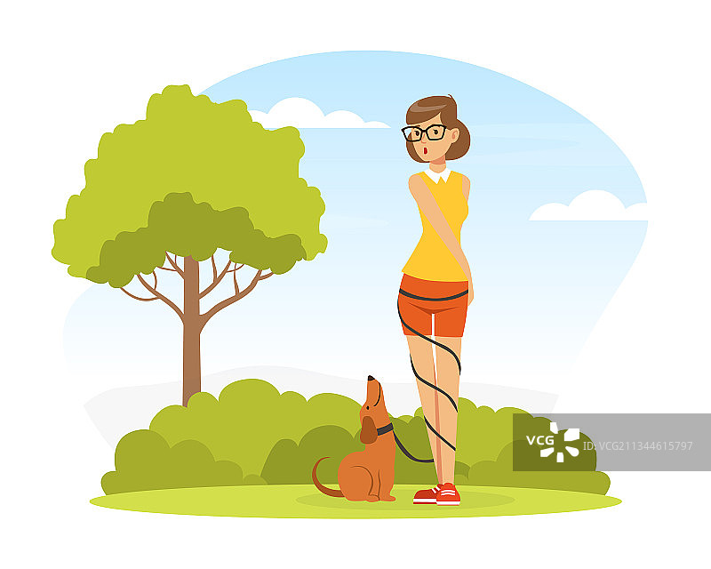 一位女宠物主人和她一起在绿色的草坪上遛狗图片素材