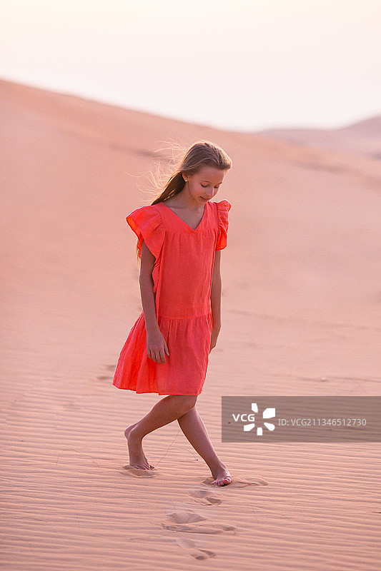 在沙漠的沙丘上行走的女孩图片素材