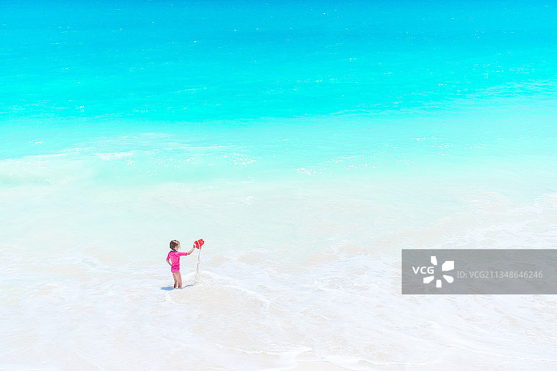 可爱的小女孩的肖像在海滩上的暑假图片素材