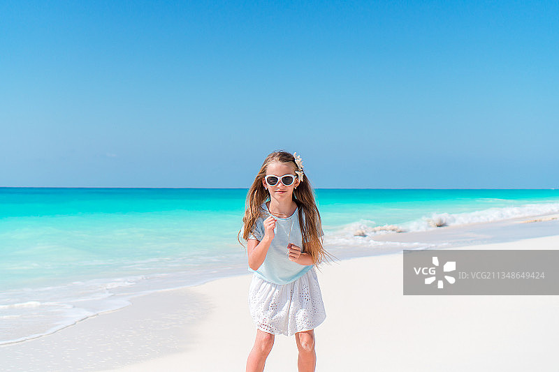 可爱的小女孩在热带海滩度假图片素材
