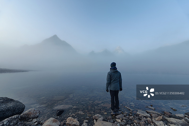 加拿大，人站在湖边的岩石上，对着图片素材