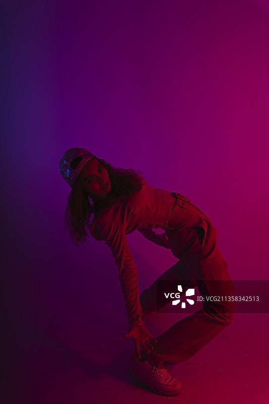 时尚肖像亚洲女孩跳舞在霓虹灯工作室的背景。图片素材