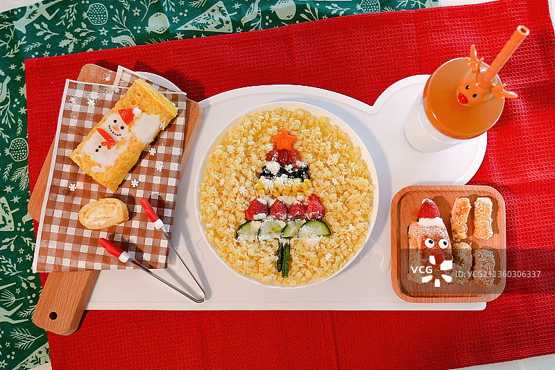 红色餐垫上的圣诞老人星星意面香煎三文鱼厚蛋烧牛奶幼儿餐图片素材
