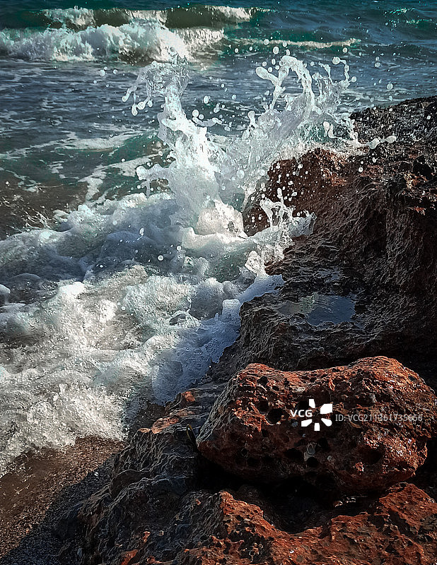 西班牙贝尼卡西姆，海浪拍打岩石的高角度视角图片素材