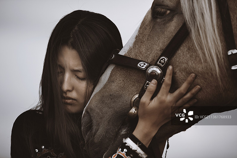 哈萨克妇女穿着民族服装，向她的马说再见图片素材