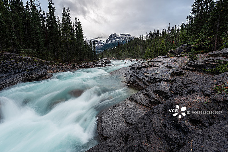 Mistaya峡谷，风景优美的河流流过岩石在森林中对着天空，加拿大图片素材