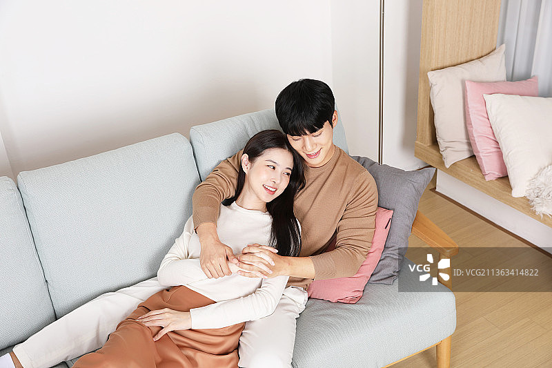 甜蜜的亚洲韩国夫妇在沙发上图片素材
