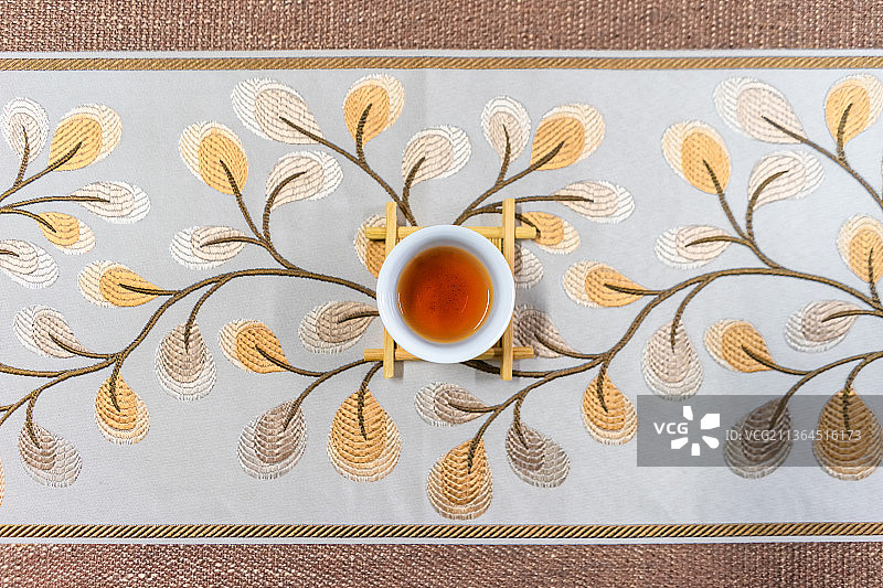中国室内茶桌上的一个倒有褐色茶水的茶杯图片素材