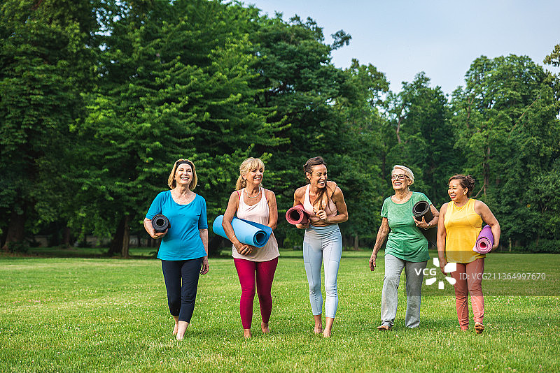 一群中老年妇女在公园健身教练的指导下训练图片素材