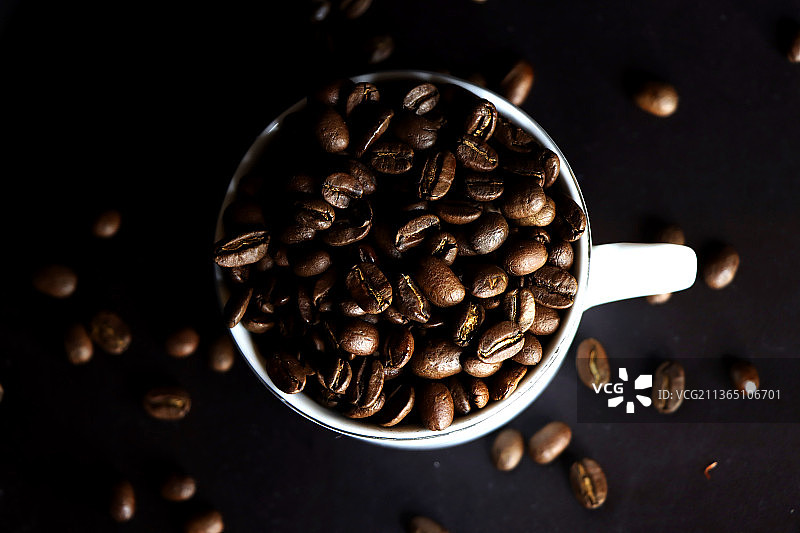 咖啡，在桌子上的杯子里的咖啡豆的高角度视图图片素材