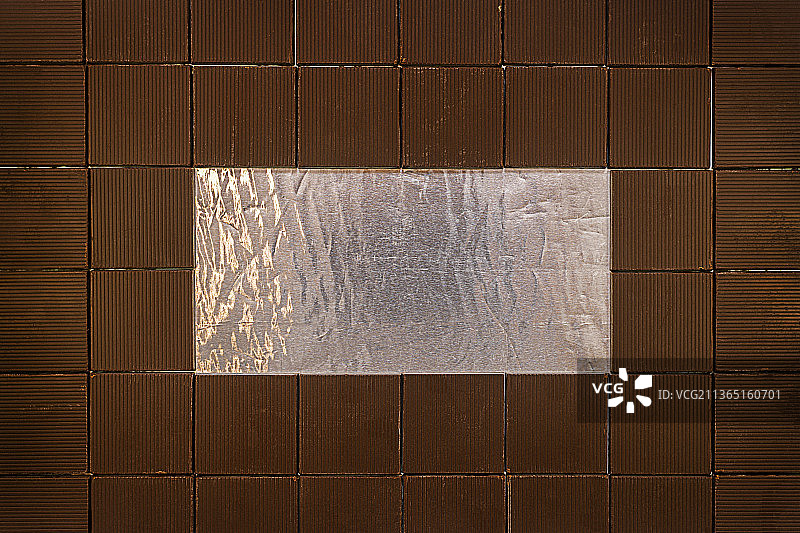 巧克力棒放在锡箔纸上，内衬一个矩形框架图片素材
