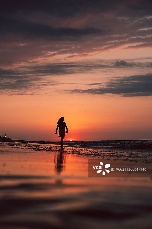 卡诺亚斯的日落，一个人的剪影站在海滩上的天空在日落，卡诺亚斯德蓬塔萨尔，秘鲁图片素材