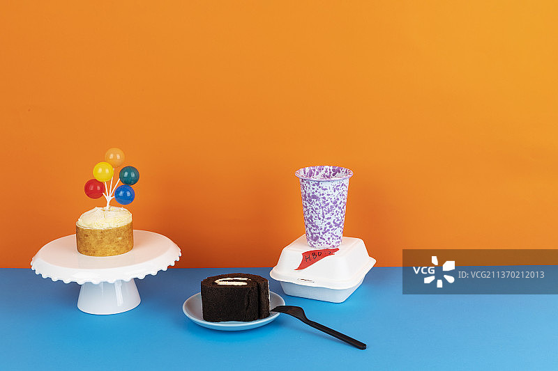 彩色好玩的派对概念迷你蛋糕气球装饰，巧克力卷蛋糕和大理石形状的杯子图片素材