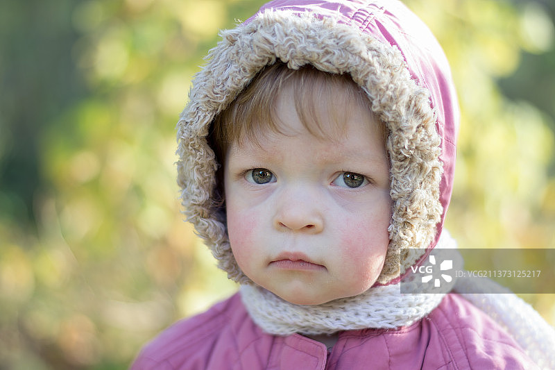一个穿着暖和夹克，面带悲伤表情的小孩图片素材