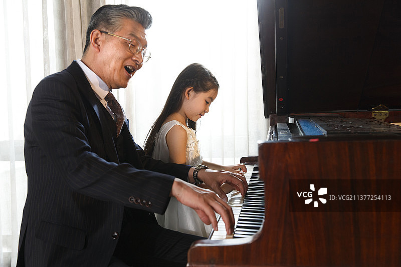 祖父和孙女一起弹钢琴图片素材
