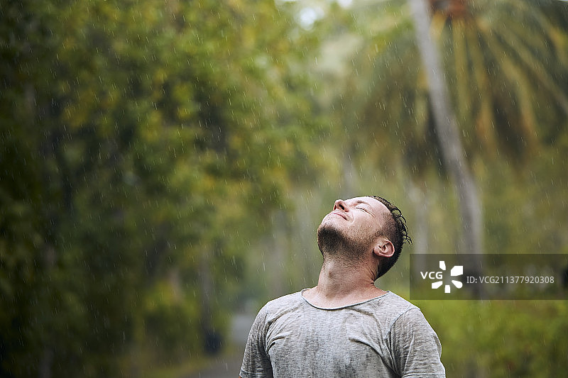 一个人闭着眼睛享受大雨图片素材