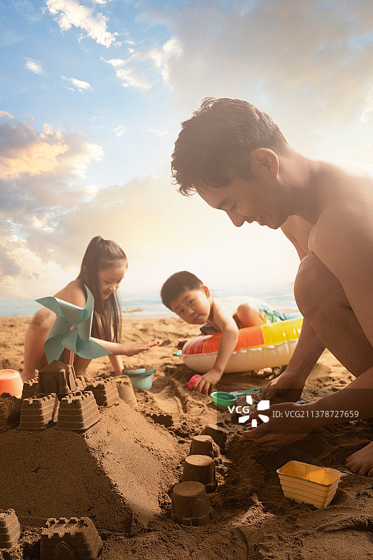 年轻父亲带着孩子们在沙滩玩耍图片素材