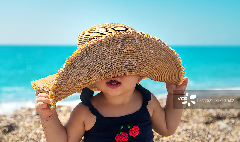 海滩上戴着帽子的婴儿选择性聚焦图片素材