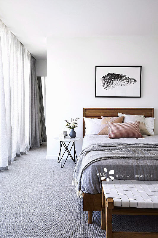 明亮的卧室里有一张单人床，铺着灰色地毯图片素材
