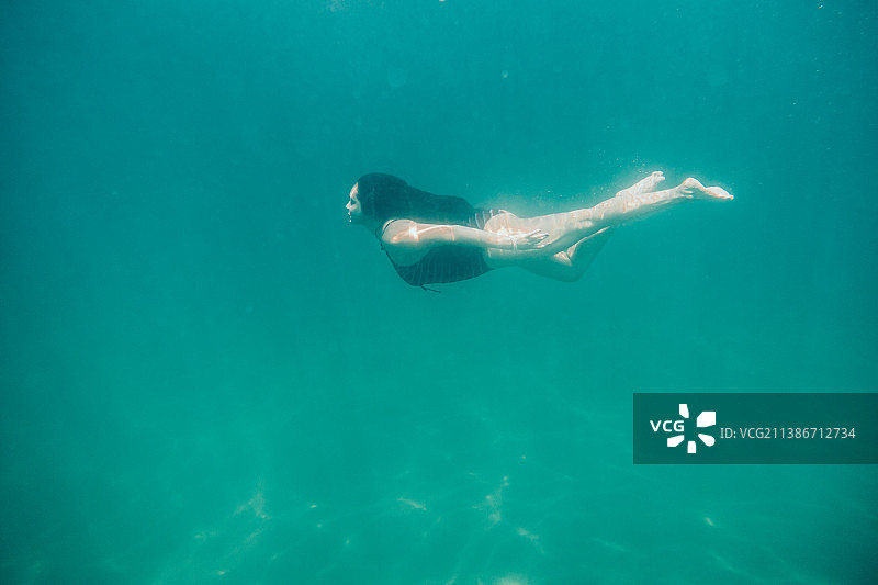 在卡诺亚斯的乐趣时光，女人在海上游泳，卡诺亚斯蓬塔萨尔，秘鲁图片素材