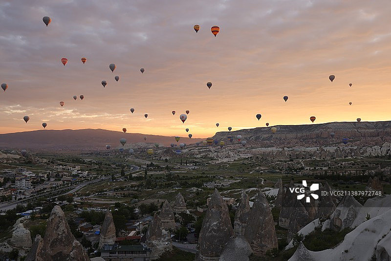 在土耳其卡帕多西亚，日落时热气球在天空中飞行的观点图片素材