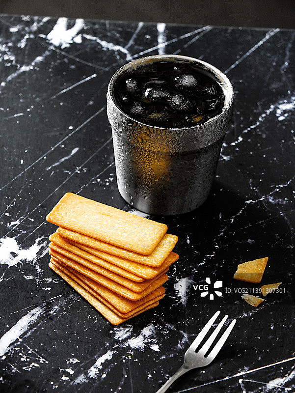 黑色花岗岩桌面上摆放着饼干和饮品咖啡图片素材