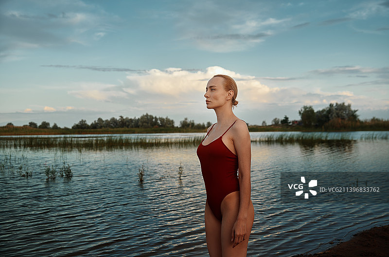 池塘边穿着红色泳衣的美女图片素材