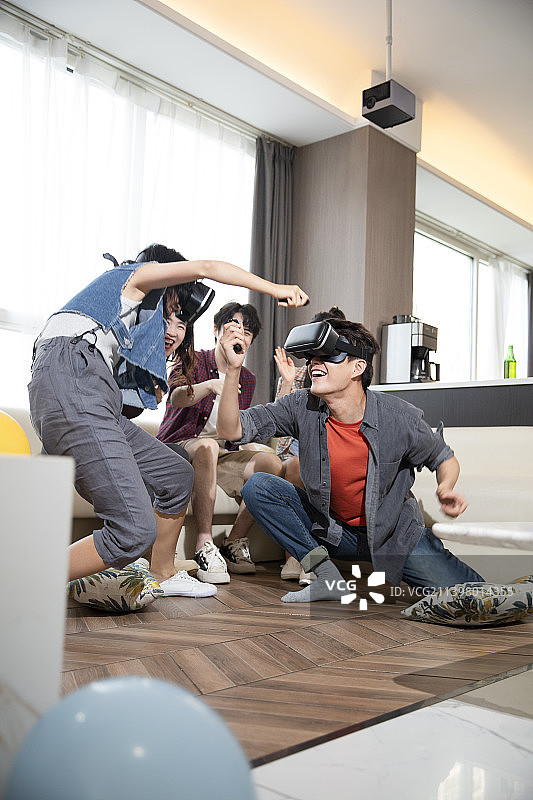 年轻朋友们在家里聚会玩VR游戏图片素材