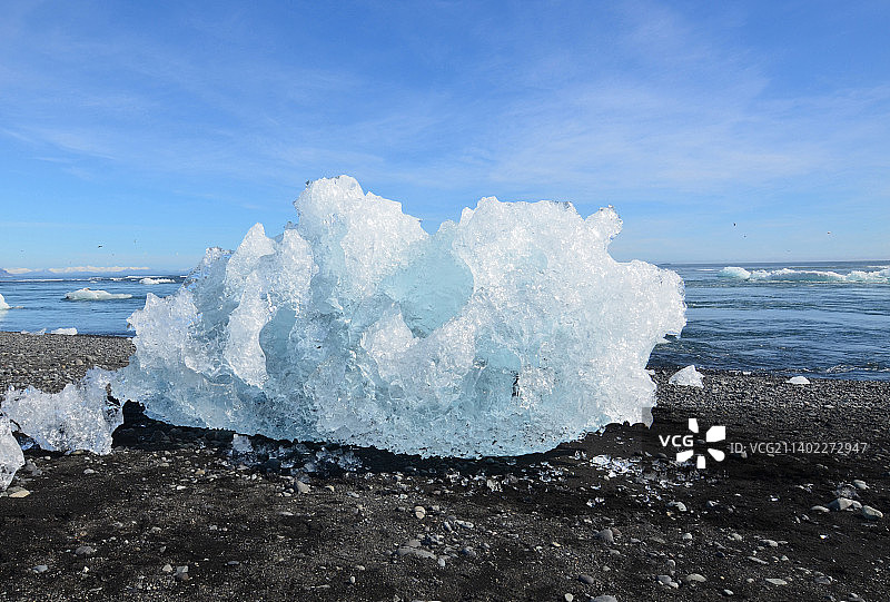 令人敬畏的冰山在泻湖海滩的黑色沙滩上图片素材