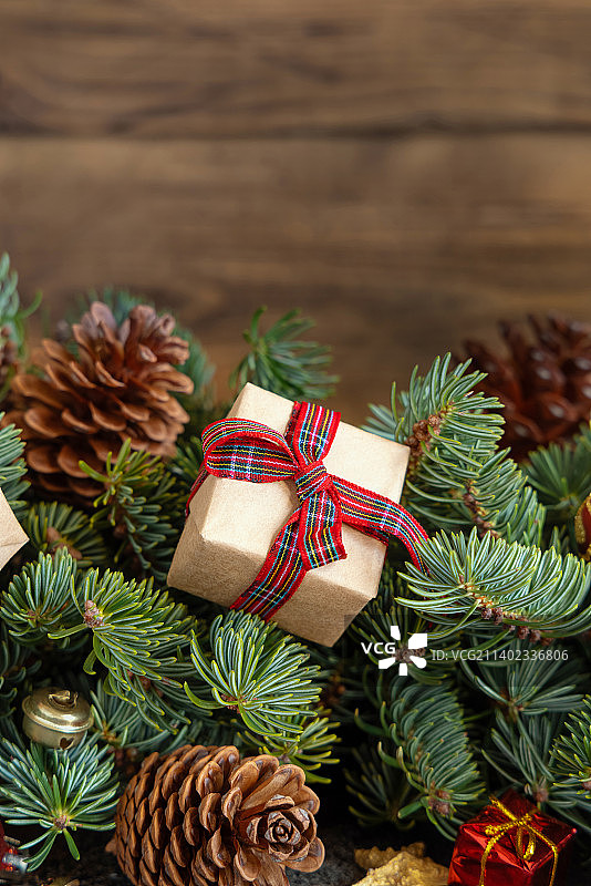 包装好的礼品盒在绿色杉树树枝附近的圣诞装饰品和松果图片素材