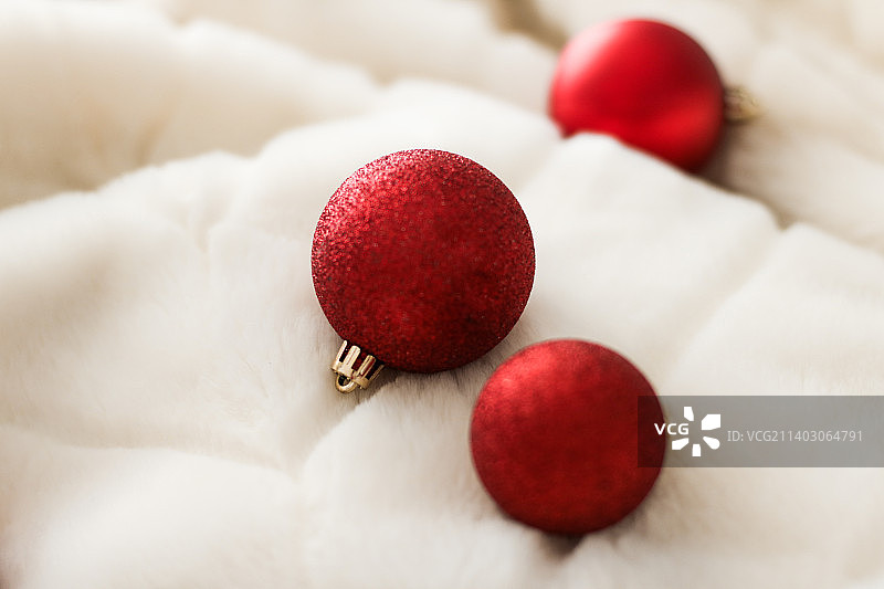 红色的圣诞装饰物在白色的毛绒背景，奢侈的冬天图片素材
