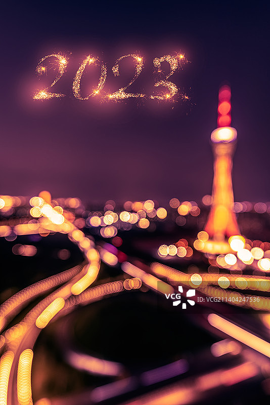 2023新年火花字和朦胧的城市建筑夜景图片素材
