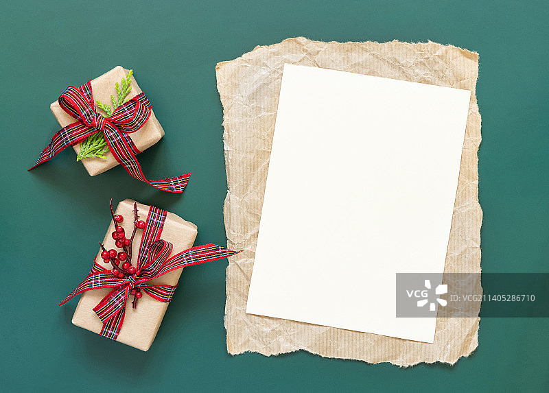 空白纸卡和包装圣诞礼物的绿色背景顶视图图片素材