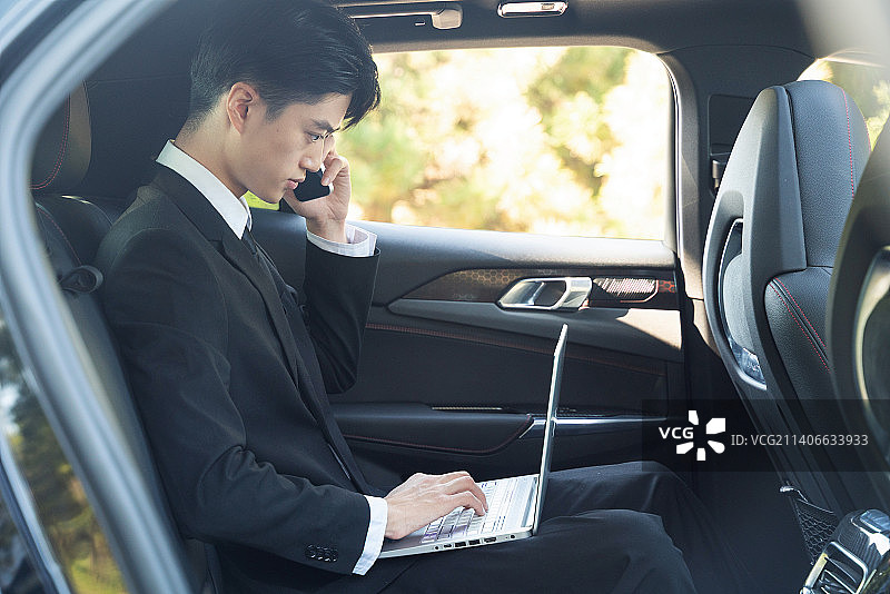 在汽车内办公的商务男士使用手机打电话图片素材