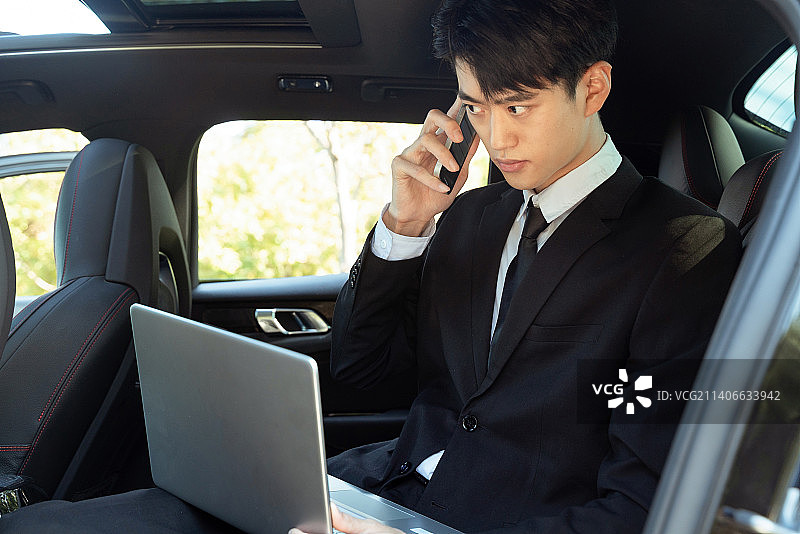 在汽车内办公的商务男士使用手机打电话图片素材