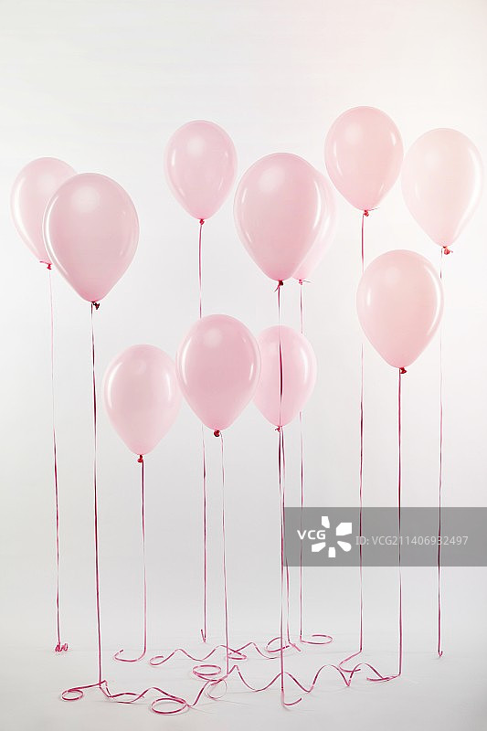白色背景下的粉色气球特写图片素材