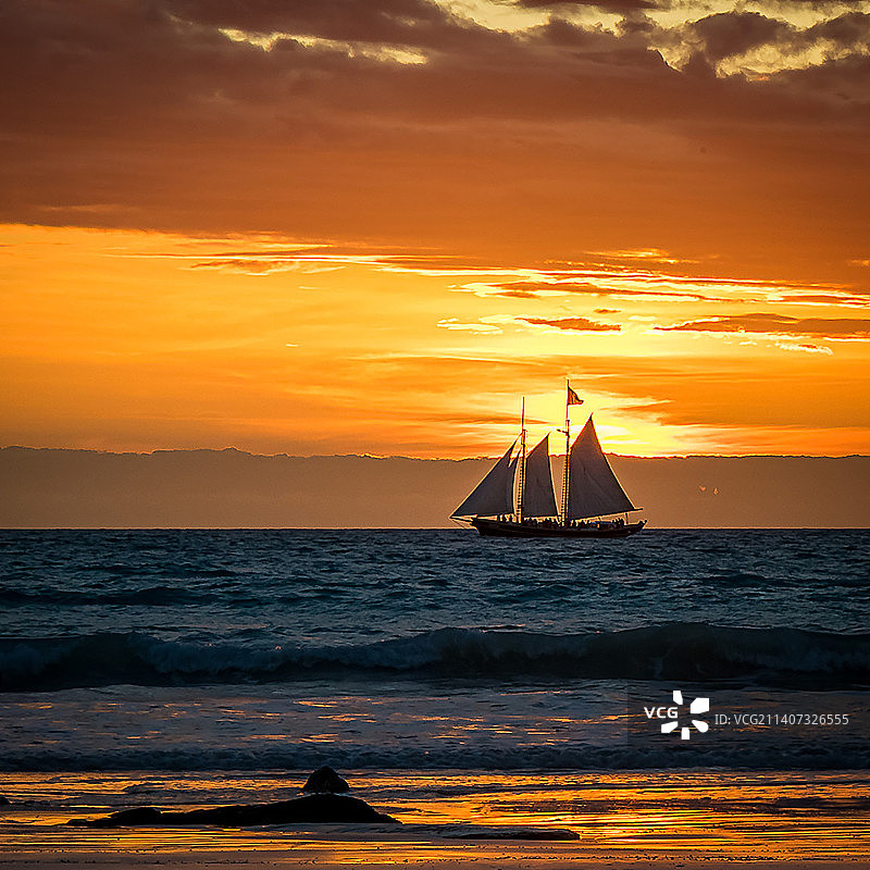 帆船的剪影在海上对着天空在日落，电缆海滩，西澳大利亚，澳大利亚图片素材