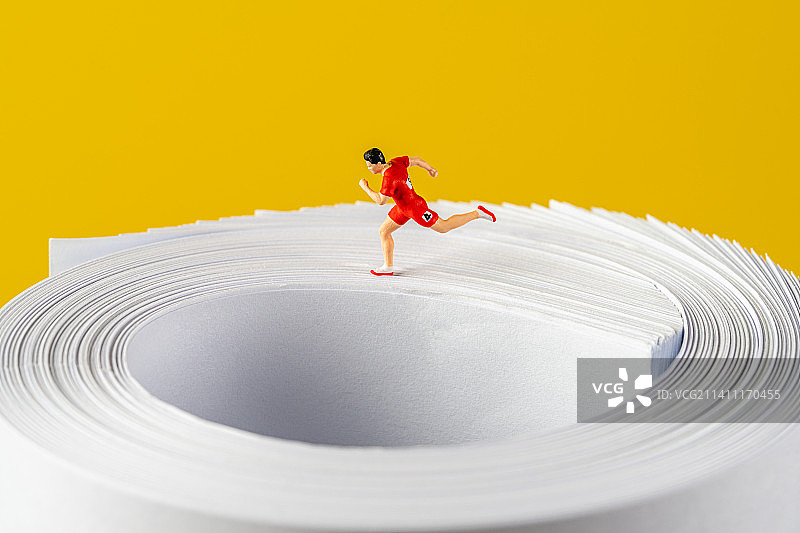 内卷运动员在卷起来的白纸上赛跑创意微缩景观图片素材
